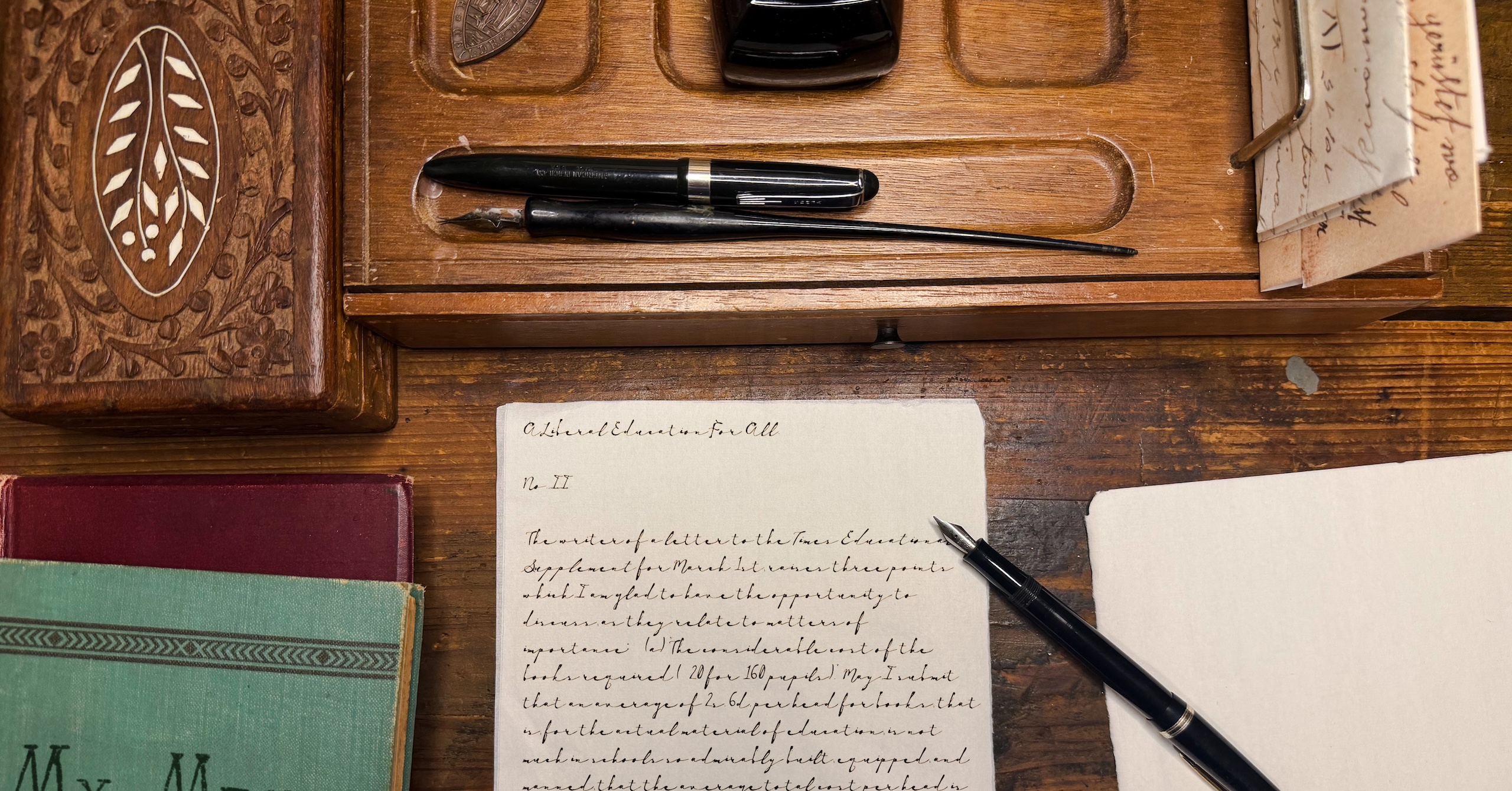 Vintage wooden desk with a fountain pen and handwritten documents, evoking old-fashioned writing.