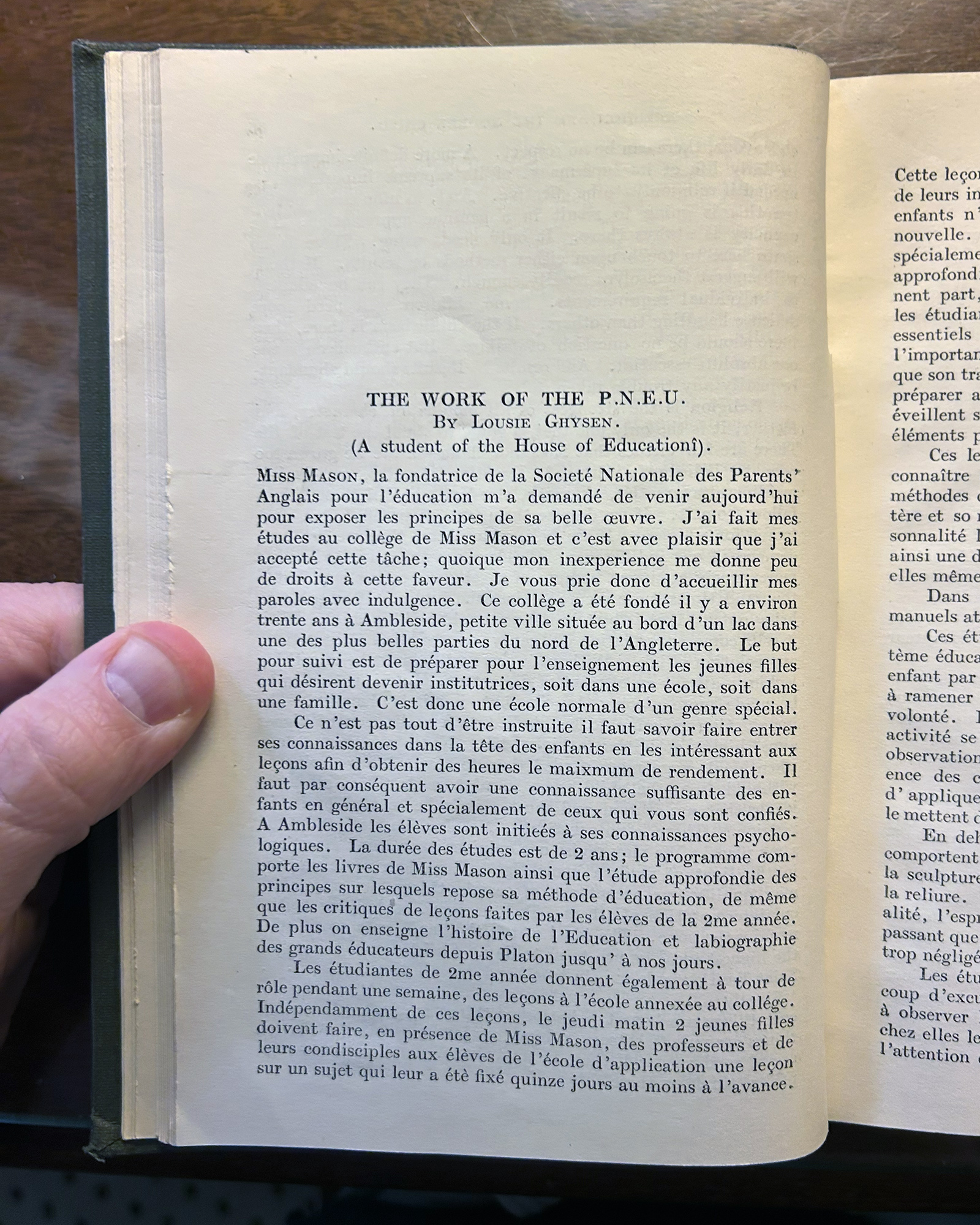 Open book page showing the title 'THE WORK OF THE P.N.E.U.' by Louise Ghysen with dense French text beneath it, held by a hand on the left edge.