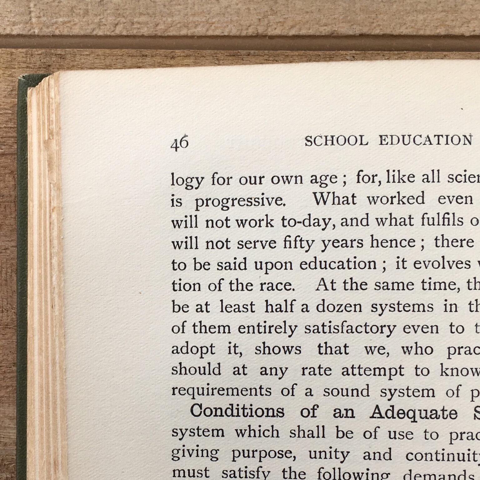 Photo of a book page with page number 46 and the heading 'SCHOOL EDUCATION' visible; dense serif text fills the page edge-to-edge.